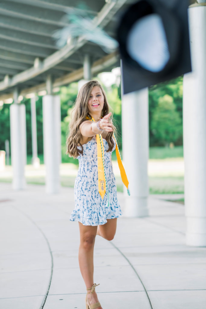 young woman throwing graduation cap in celebration