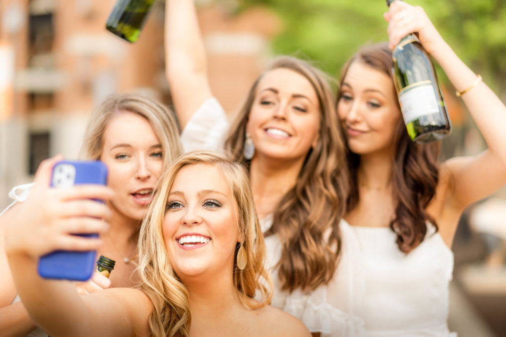 girls taking pictures on college campus celebrating college graduation