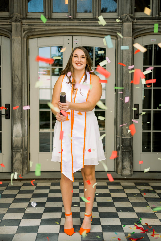 young woman celebrating graduation with confetti during session