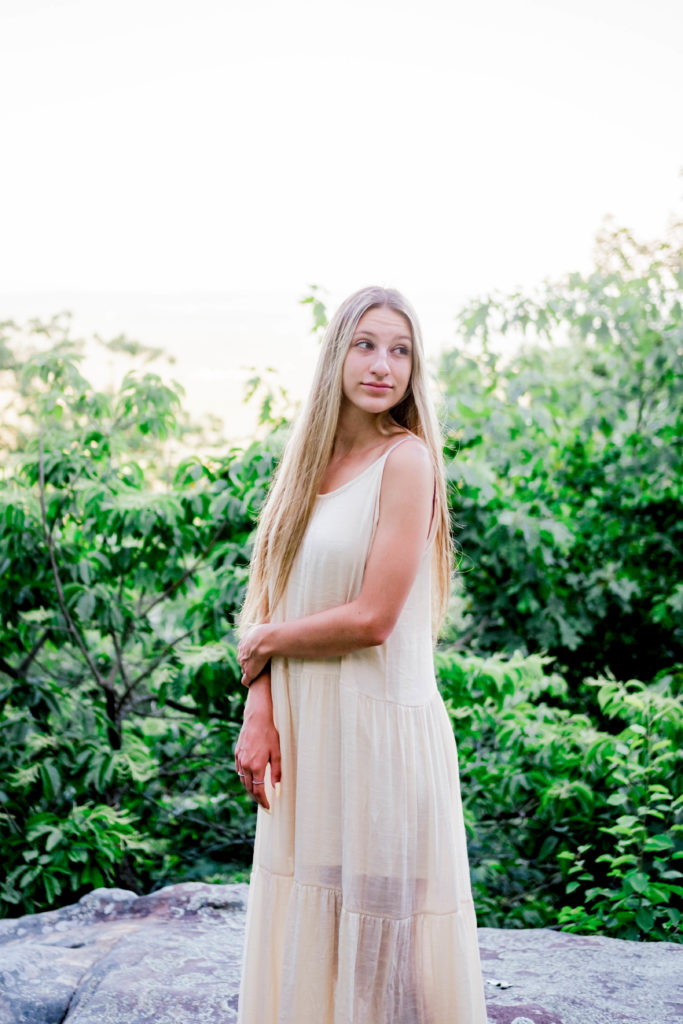 young woman wearing cream dress in forest green 