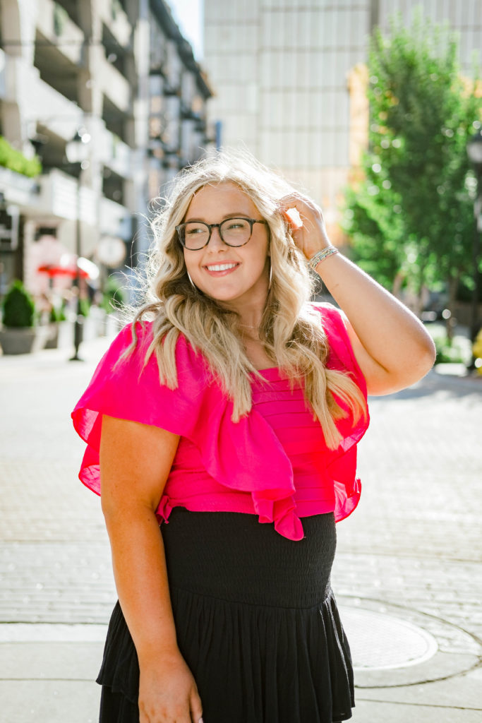 young woman wearing pink top and black skirt during downtown Chattanooga senior session