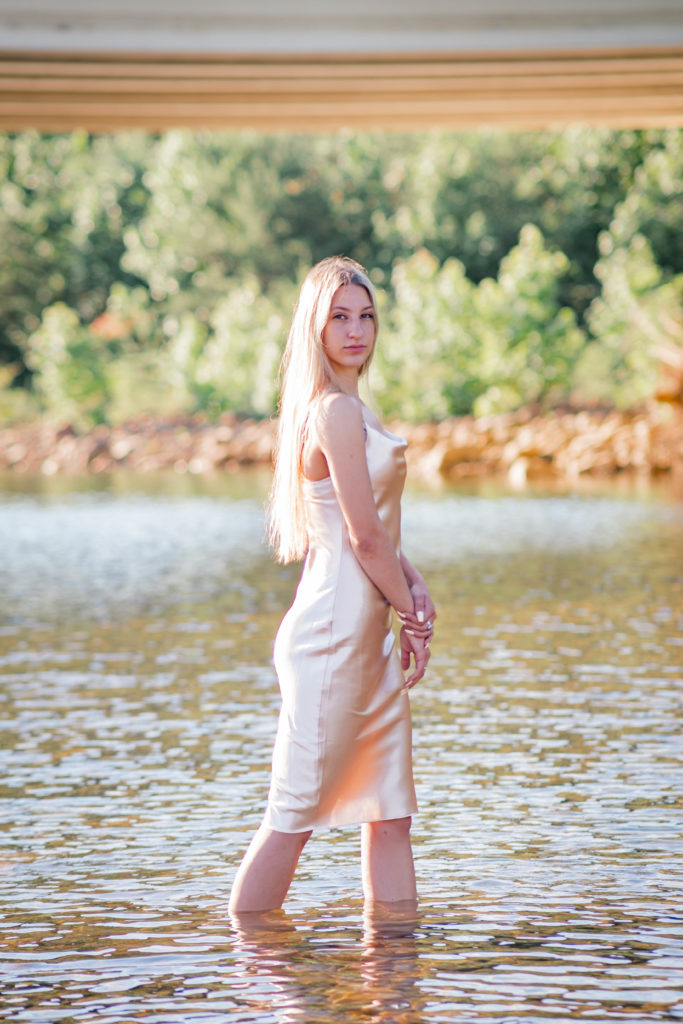 young woman wearing champagne silk dress in creek during chattanooga outdoor senior session