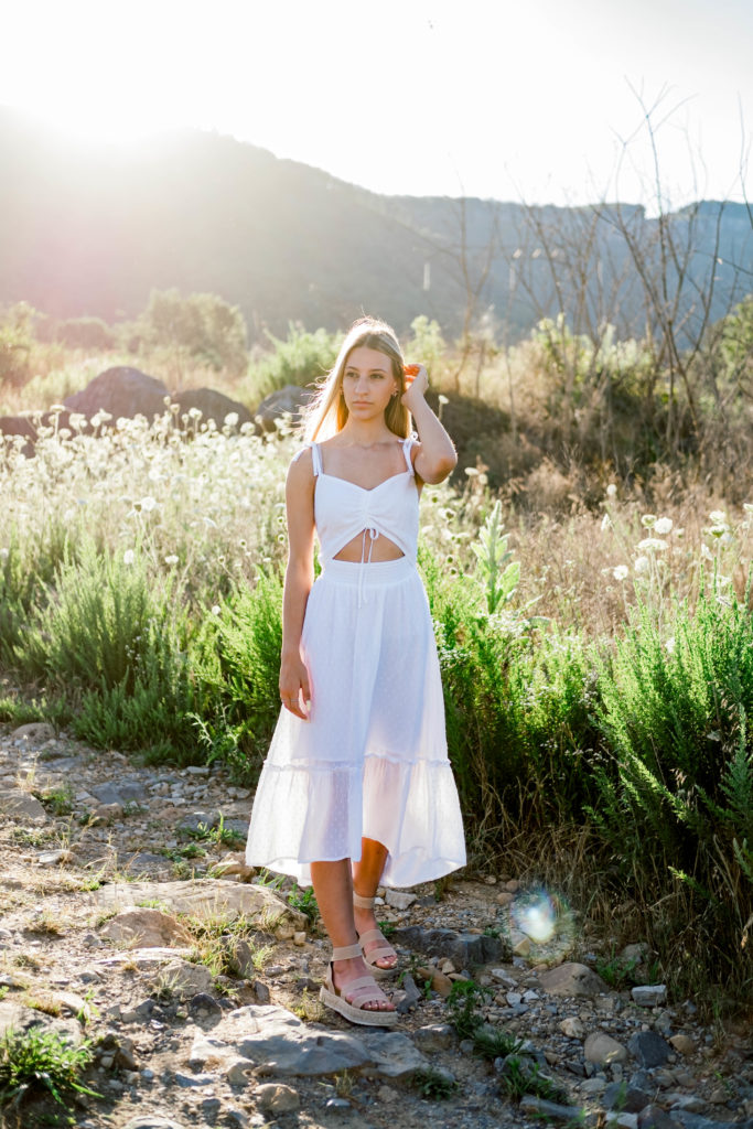 young high school senior wearing white dress in field