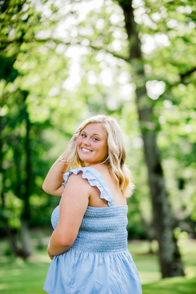 Young Tennessee senior wearing blue tank smiling in forest