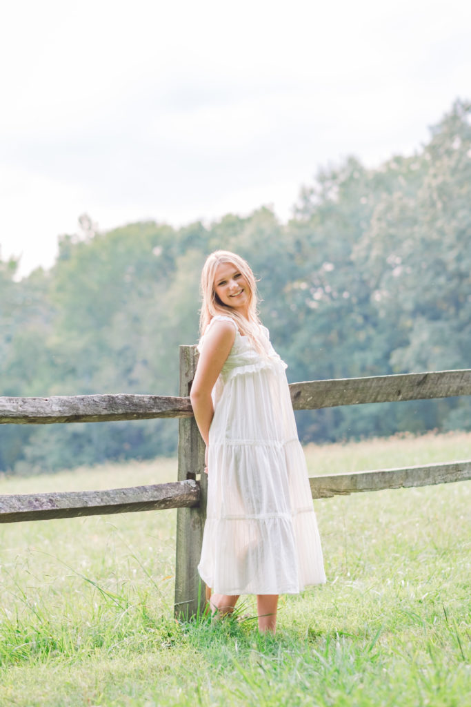 Tennessee senior wearing white dress in outdoor field during session