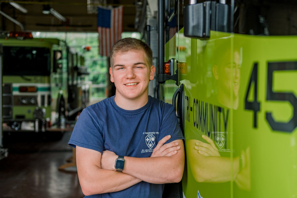 young tennessee senior leaning against fire truck during east hamilton senior session