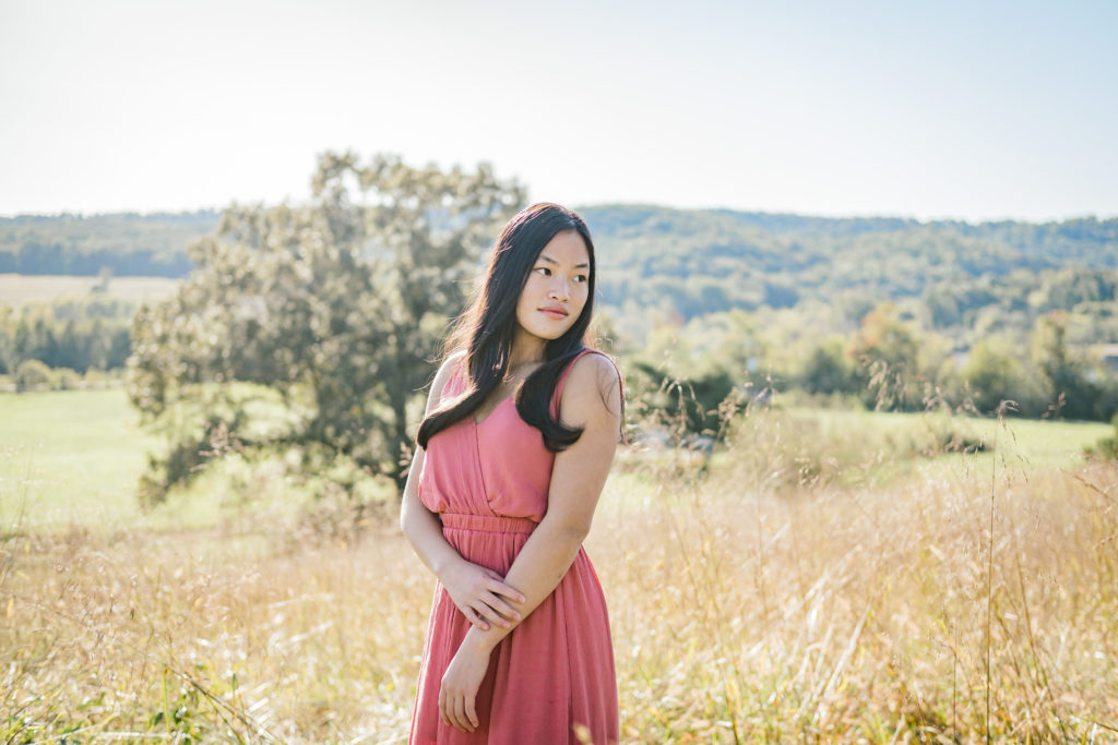 young woman wearing pink dress during outdoor senior portraits
