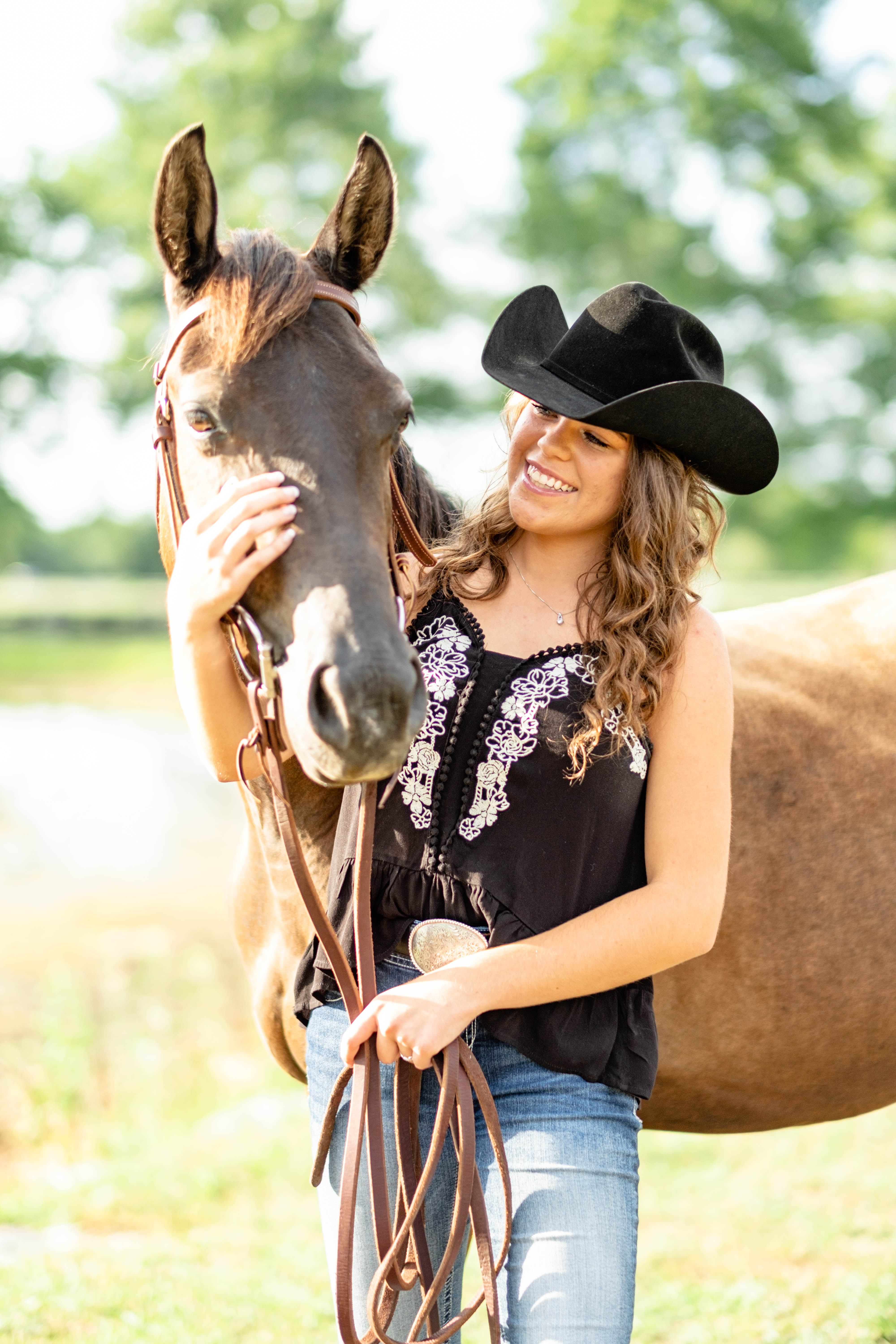 Woman holding horse in senior pictures