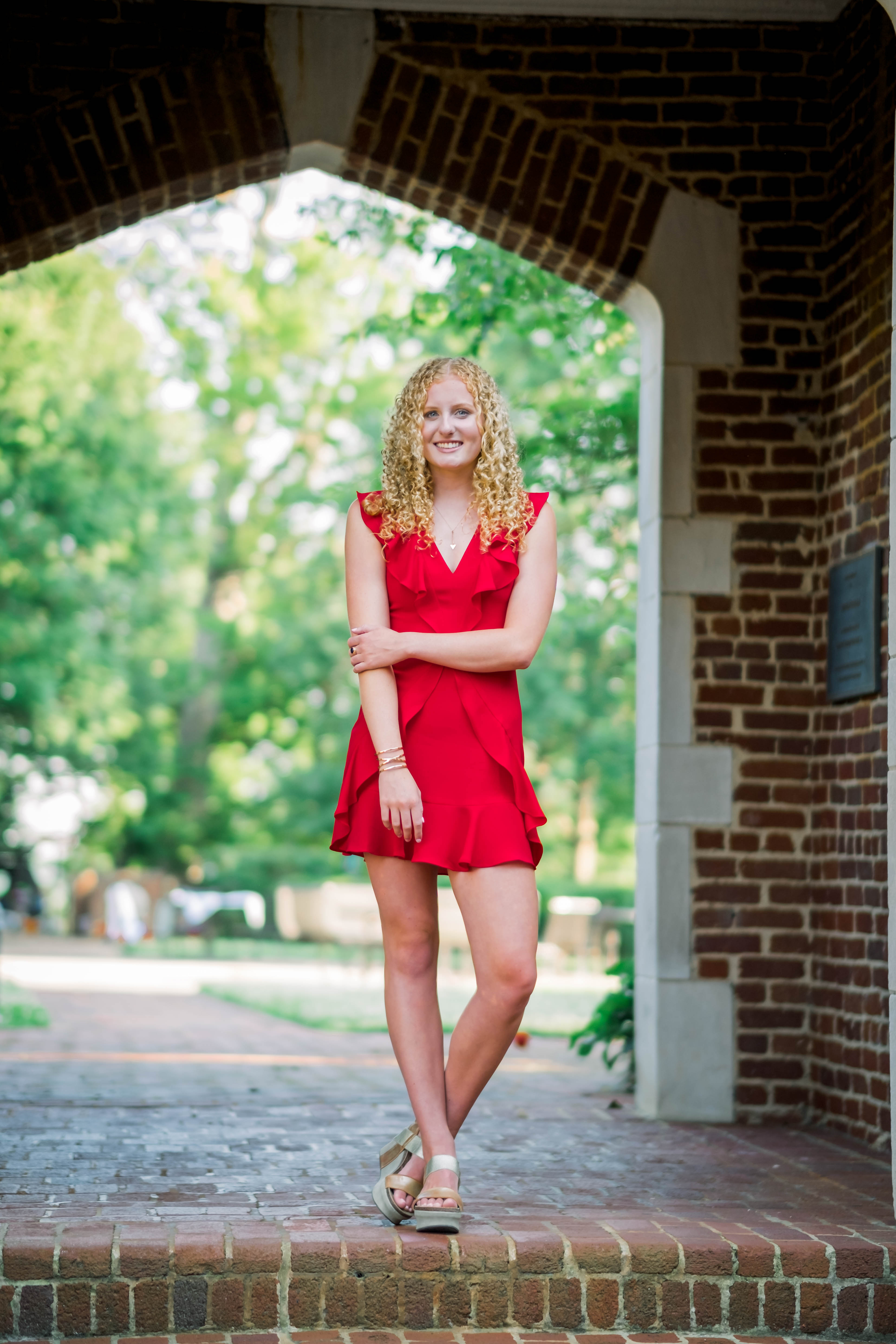 young woman walking through school campus for senior pictures