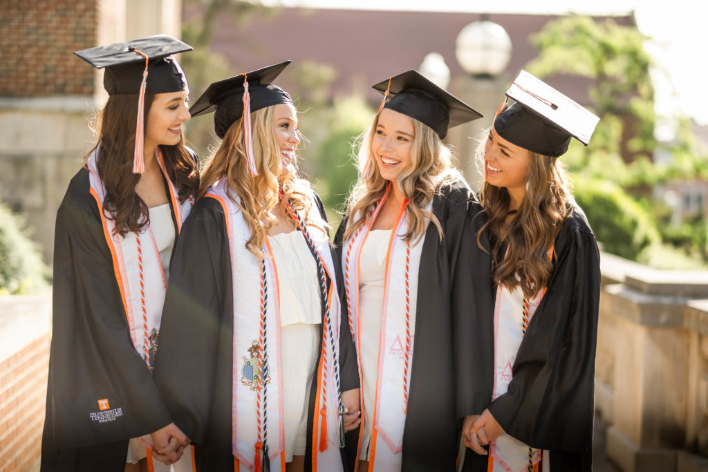 group of women wearing graduation gowns celebrating