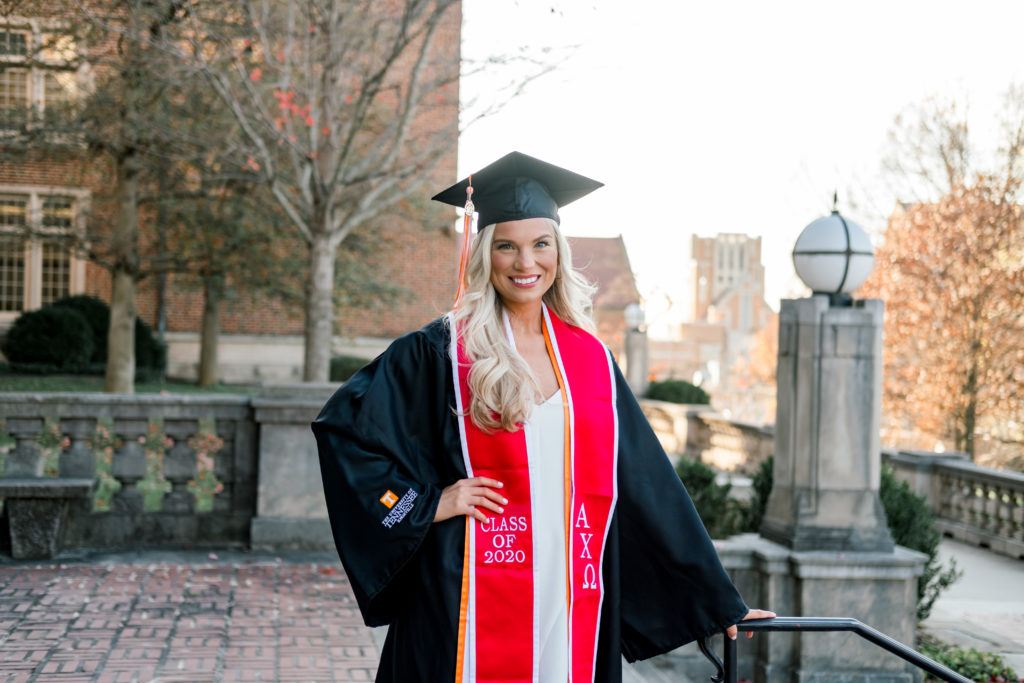 woman standing with hand on hips in graduation gown