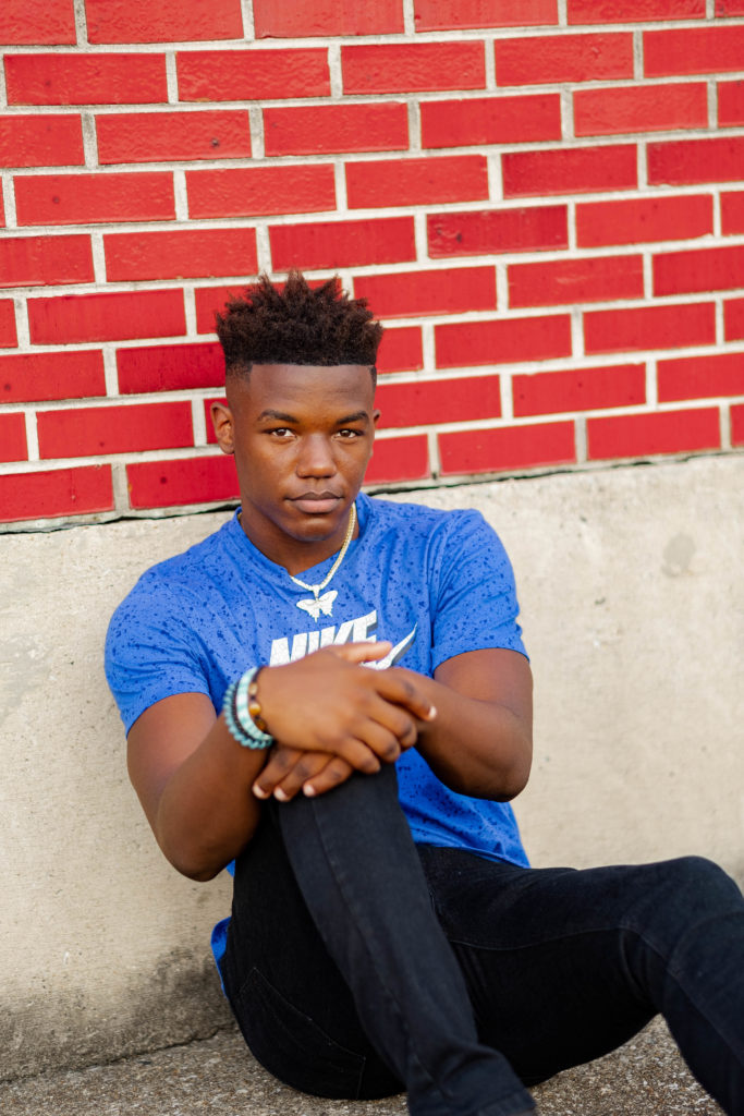 tennessee senior standing against brick wall during chattanooga senior session