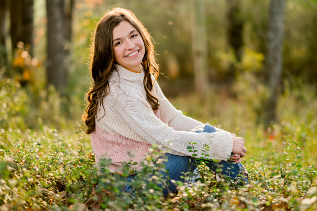 golden hour senior session in knoxville tennessee in the fall with high school senior wearing a pink and cream sweater. 