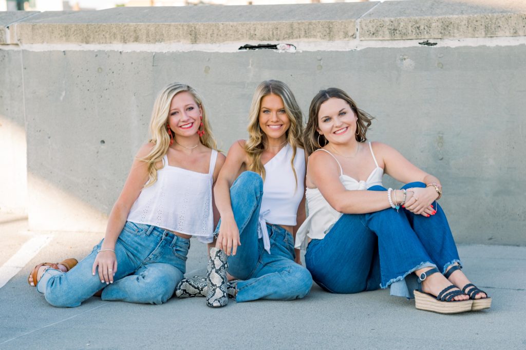 knoxville high school seniors gather on top of a building to take gorgeous group senior session at golden hour.
