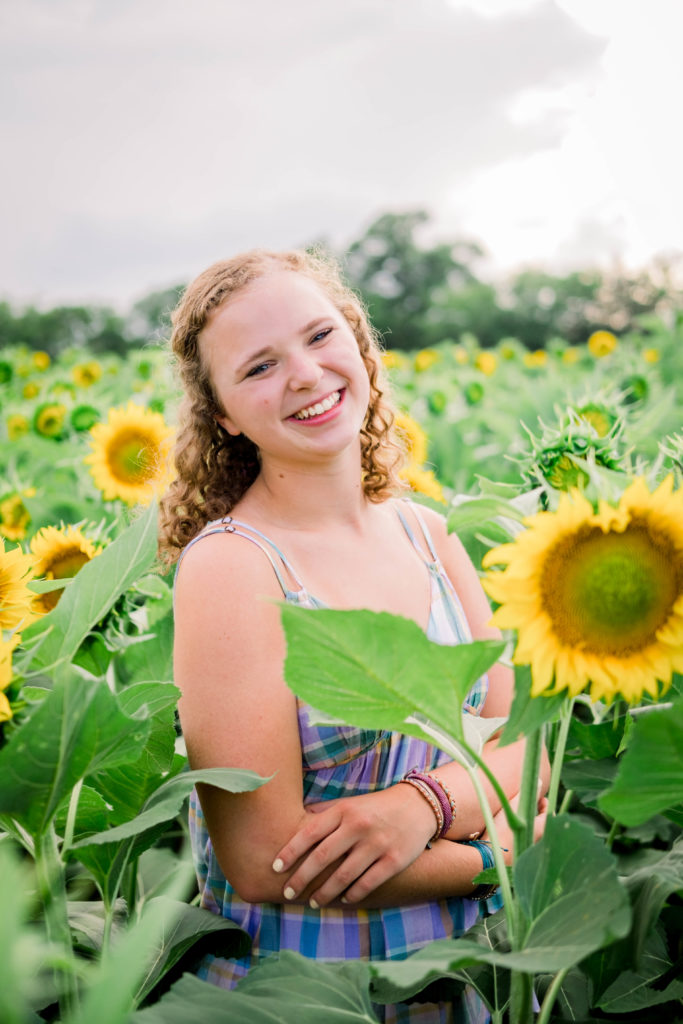 young girl smiling and laughing at camera during Ooltewah sunflower senior session