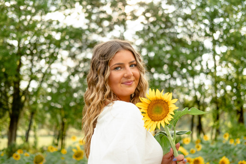 Tennessee senior holding sunflower during outdoor tennessee senior session