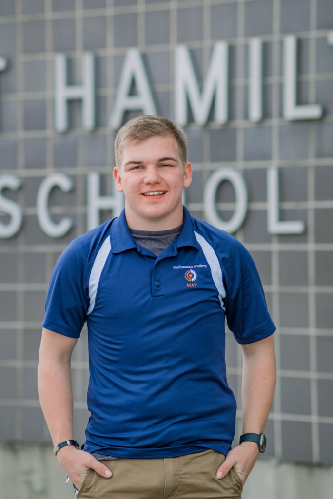 Tennessee senior smiling in front of high school during portraits
