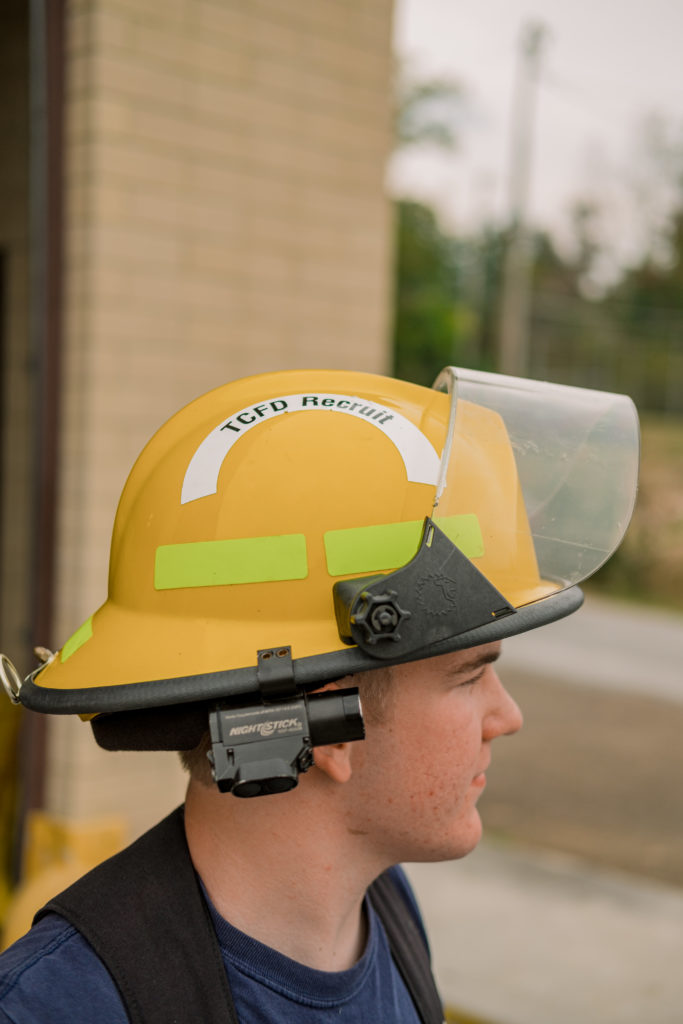 young volunteer firefighter wearing helmet during east hamilton senior session